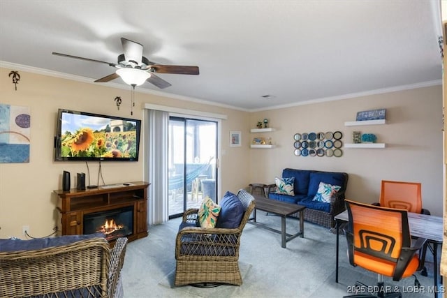 carpeted living area with a glass covered fireplace, ceiling fan, and crown molding