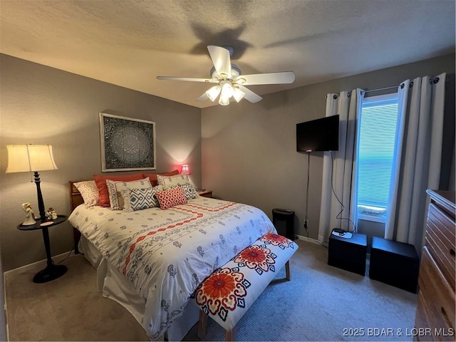 carpeted bedroom with a ceiling fan, baseboards, and a textured ceiling