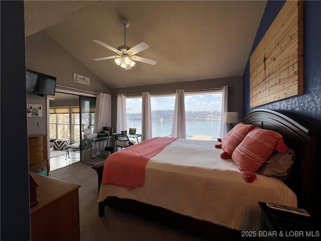 carpeted bedroom featuring access to exterior, a ceiling fan, a water view, and vaulted ceiling