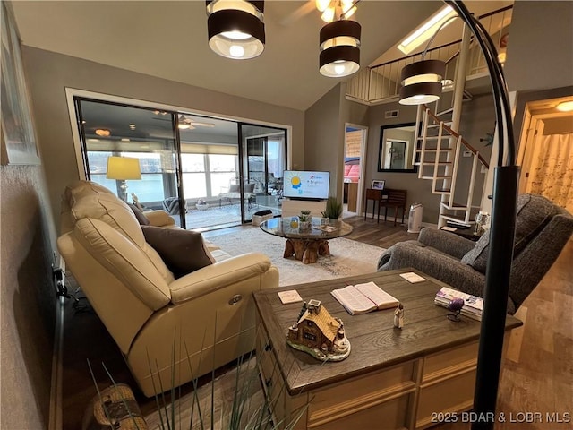 living room featuring stairway, lofted ceiling, and wood finished floors