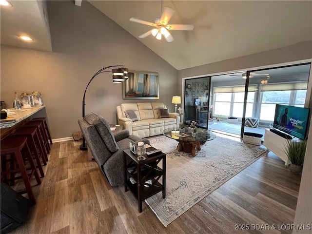 living room featuring baseboards, high vaulted ceiling, ceiling fan, and wood finished floors