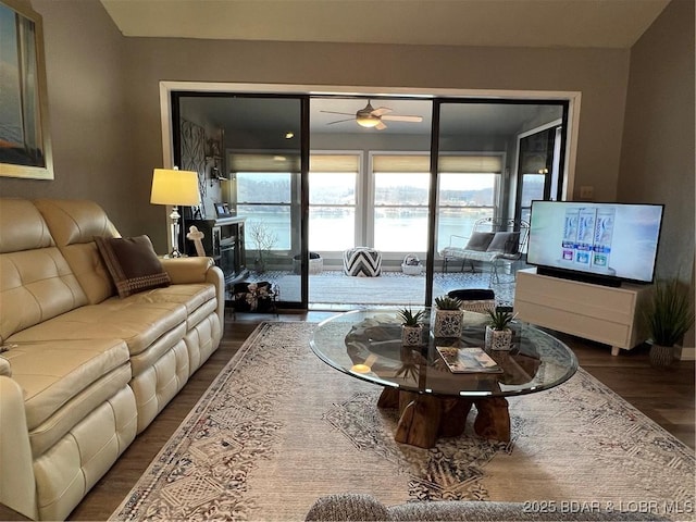 living room featuring dark wood-style flooring and a ceiling fan