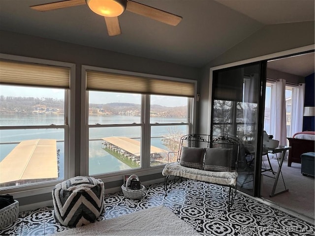 interior space with carpet, lofted ceiling, ceiling fan, and a water view