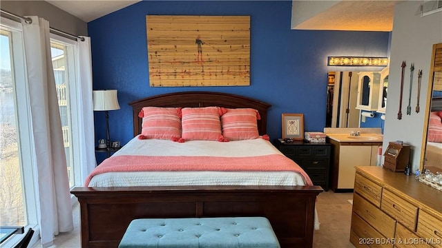 carpeted bedroom featuring visible vents, a sink, and vaulted ceiling