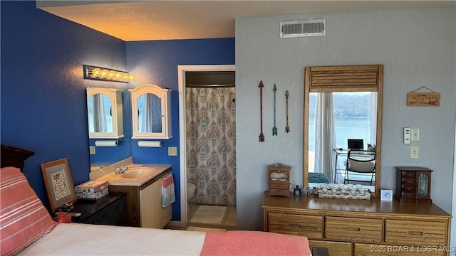 bedroom with visible vents and a sink