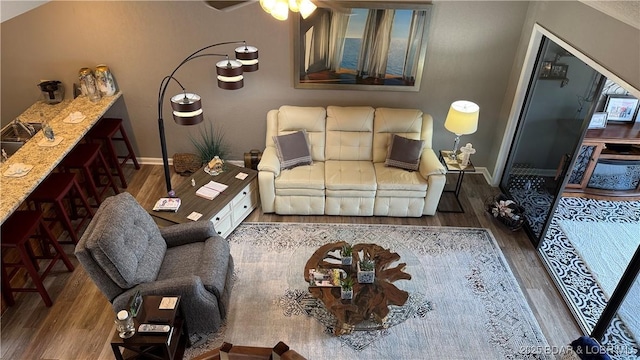 living area with baseboards, a ceiling fan, and wood finished floors