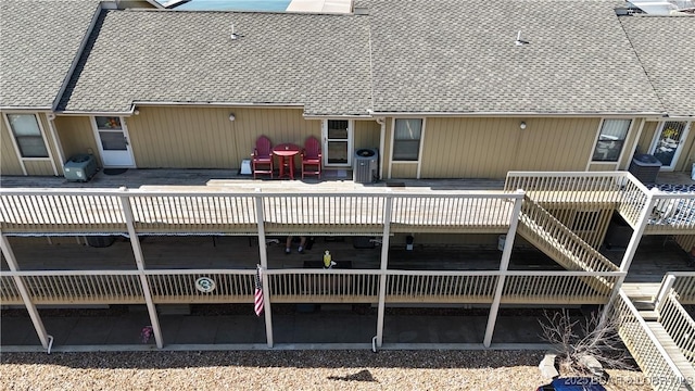 back of property featuring a deck and stairs