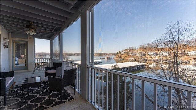 balcony featuring ceiling fan and a water view