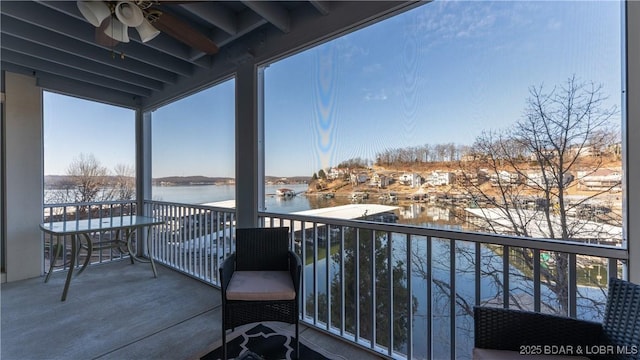 balcony featuring ceiling fan and a water view