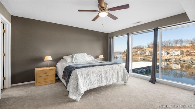 bedroom with visible vents, light colored carpet, and a ceiling fan