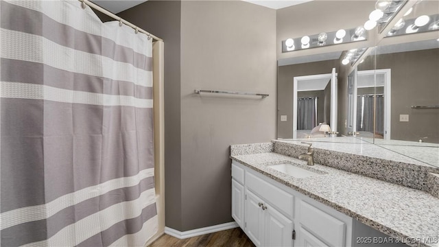 full bathroom with vanity, a shower with curtain, wood finished floors, and baseboards