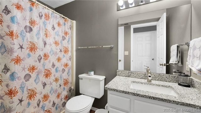 bathroom with toilet, vanity, and a shower with curtain