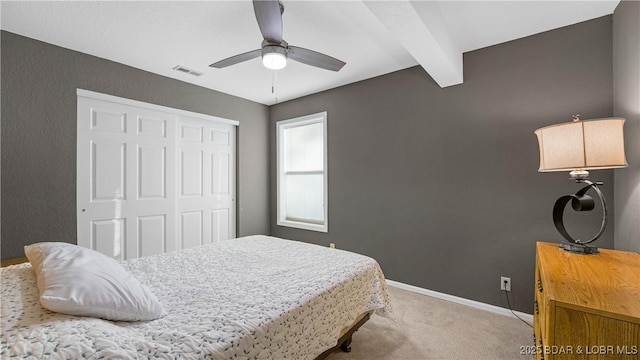 bedroom with visible vents, beam ceiling, a closet, carpet, and baseboards