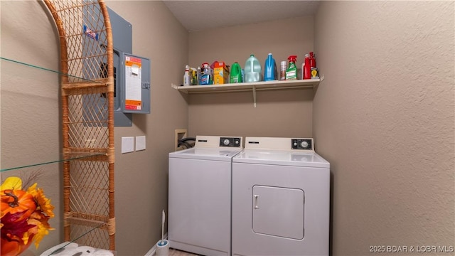 laundry room with washer and clothes dryer, laundry area, and a textured wall