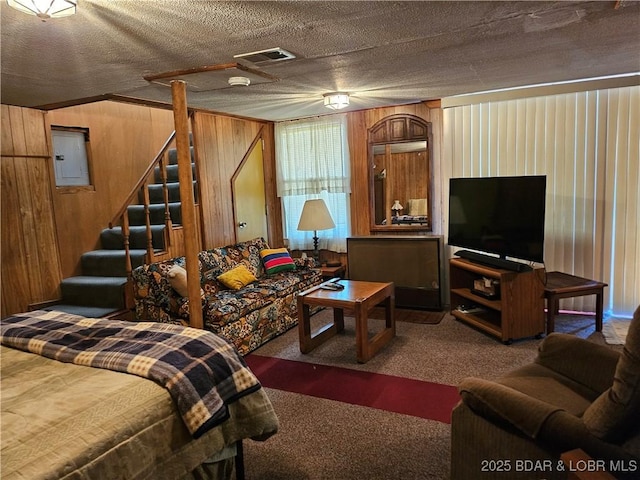 33 Zebco Ct, Edwards, MO 65326 - living room with visible vents, electric panel, a textured ceiling, wood walls, and carpet flooring