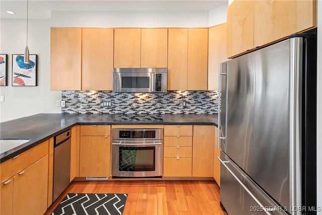 145 Bella Terra Ct, Sunrise Beach, MO 65079 - kitchen with dark countertops, backsplash, light wood-type flooring, and appliances with stainless steel finishes