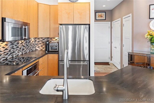 145 Bella Terra Ct, Sunrise Beach, MO 65079 - kitchen featuring modern cabinets, light brown cabinetry, tasteful backsplash, dark countertops, and stainless steel appliances