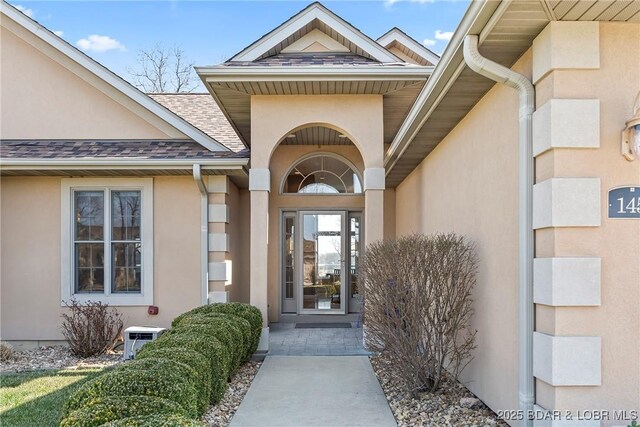 145 Bella Terra Ct, Sunrise Beach, MO 65079 - view of exterior entry featuring stucco siding and a shingled roof