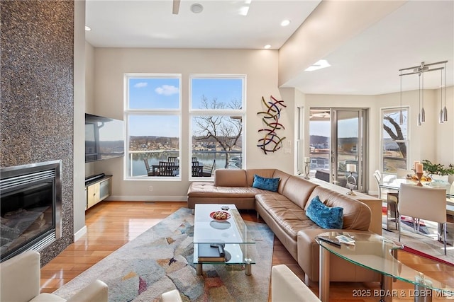 145 Bella Terra Ct, Sunrise Beach, MO 65079 - living room with a fireplace, wood finished floors, baseboards, and a wealth of natural light