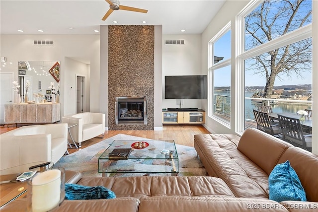 145 Bella Terra Ct, Sunrise Beach, MO 65079 - living room with visible vents, a large fireplace, ceiling fan, and wood finished floors