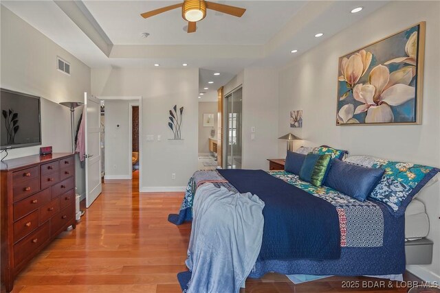 145 Bella Terra Ct, Sunrise Beach, MO 65079 - bedroom with light wood-type flooring, visible vents, a tray ceiling, recessed lighting, and baseboards