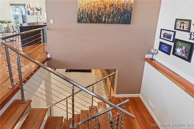 145 Bella Terra Ct, Sunrise Beach, MO 65079 - staircase featuring baseboards and wood finished floors