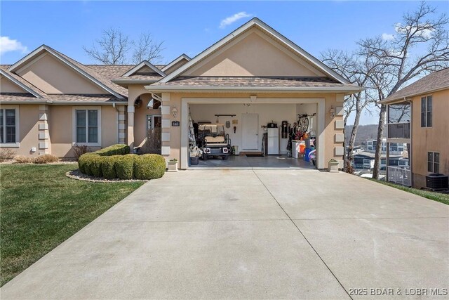 145 Bella Terra Ct, Sunrise Beach, MO 65079 - view of front of house with stucco siding, a front lawn, concrete driveway, and a garage