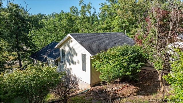 view of side of property featuring roof with shingles