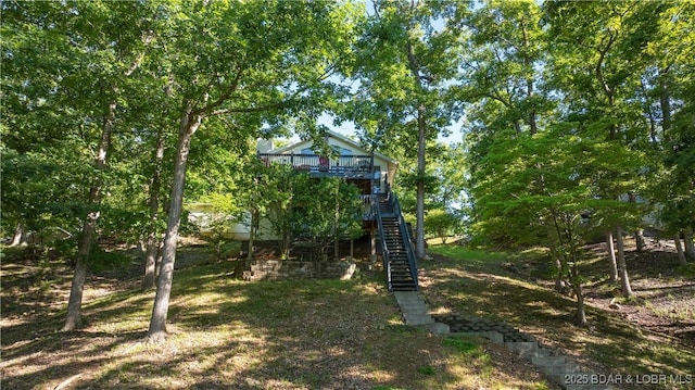 view of yard with a wooden deck and stairs