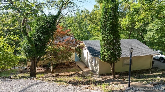 view of side of home with a shingled roof