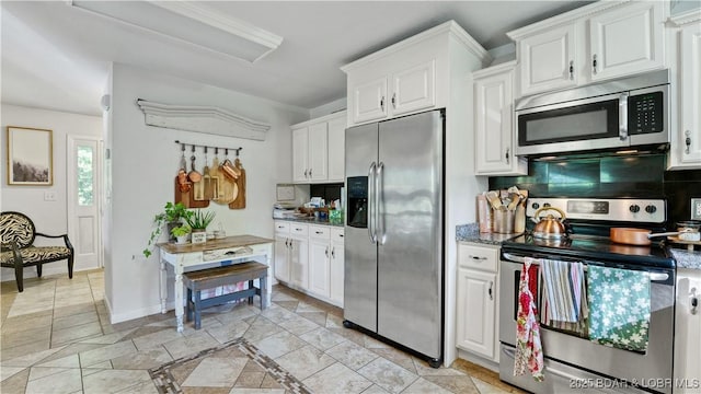 kitchen featuring baseboards, stainless steel appliances, and white cabinetry