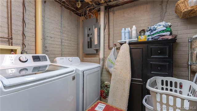 laundry area with washer and dryer, laundry area, brick wall, and electric panel