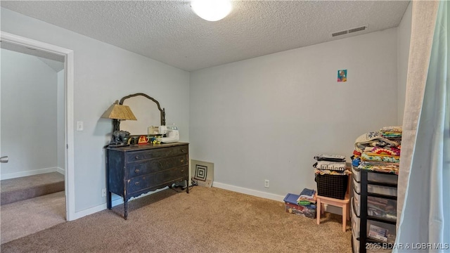 carpeted bedroom with visible vents, a textured ceiling, and baseboards