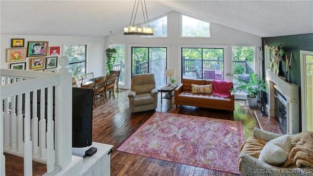 living room featuring a chandelier, a textured ceiling, vaulted ceiling, and hardwood / wood-style floors