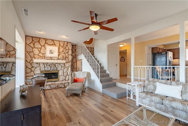 889 Malibu Rd Unit 91, Osage Beach, MO 65065 - living room featuring a fireplace, light wood-style floors, ceiling fan, stairway, and lofted ceiling