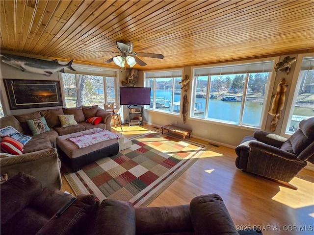living room with wooden ceiling, a healthy amount of sunlight, and wood finished floors