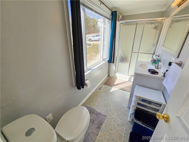 bathroom with vanity, toilet, baseboards, visible vents, and a stall shower