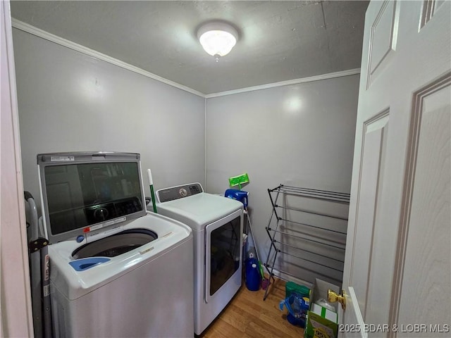 laundry area featuring independent washer and dryer, laundry area, ornamental molding, and wood finished floors