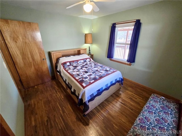 bedroom with a ceiling fan, baseboards, and wood finished floors