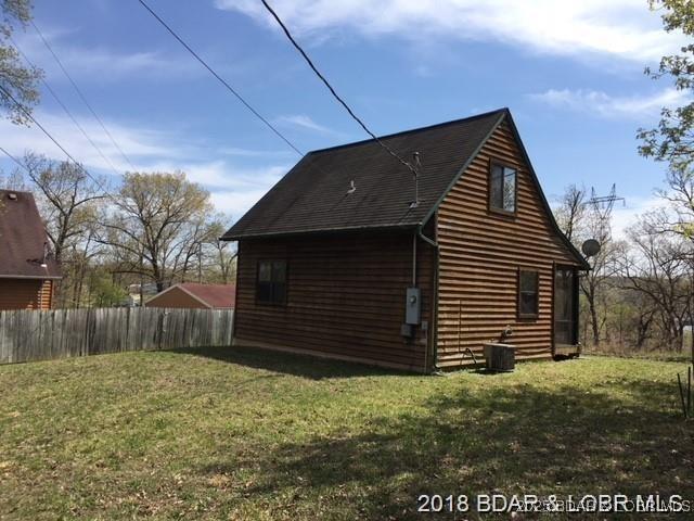 view of side of home featuring fence, a yard, and central air condition unit