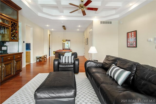 living room with visible vents, dark wood-type flooring, recessed lighting, coffered ceiling, and a ceiling fan