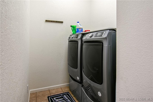 laundry room featuring tile patterned floors, separate washer and dryer, baseboards, laundry area, and a textured wall
