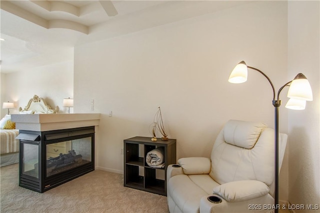 living area featuring carpet floors and a ceiling fan