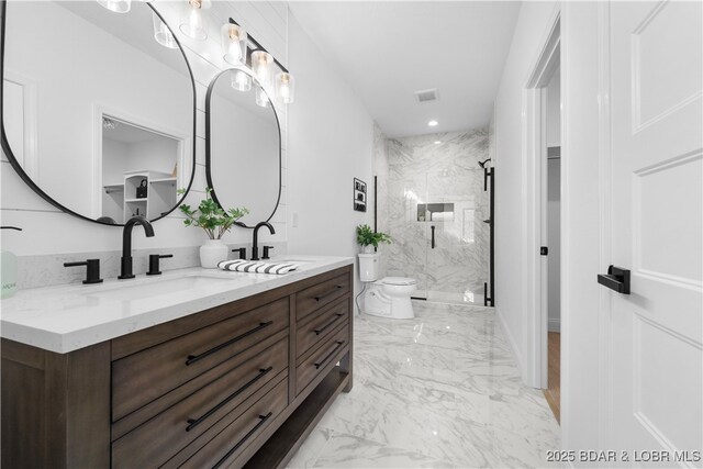 bathroom featuring marble finish floors, toilet, a marble finish shower, and double vanity