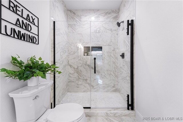 bathroom with toilet, a marble finish shower, and marble look tile flooring