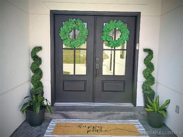 entrance to property with french doors and stucco siding