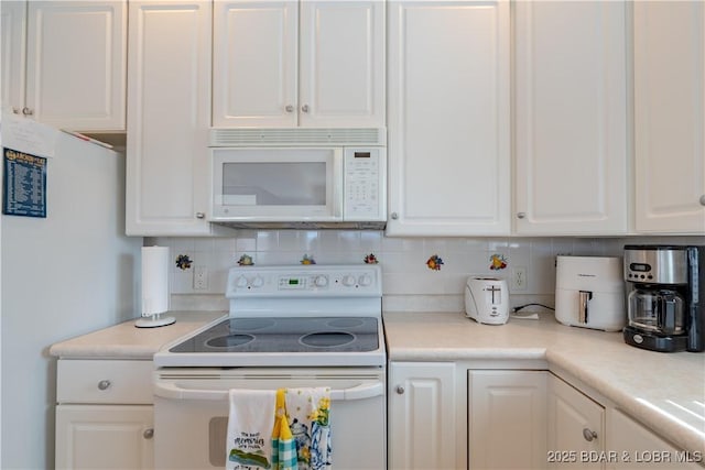 kitchen featuring white appliances, tasteful backsplash, light countertops, and white cabinetry