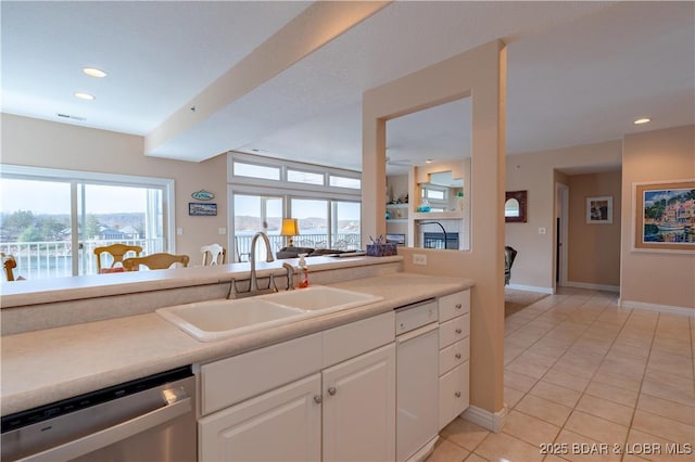 kitchen featuring light tile patterned floors, recessed lighting, a sink, white cabinets, and stainless steel dishwasher