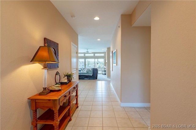 hallway featuring light tile patterned floors, recessed lighting, and baseboards