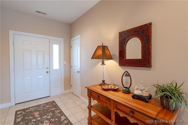 foyer entrance featuring tile patterned floors, baseboards, and visible vents